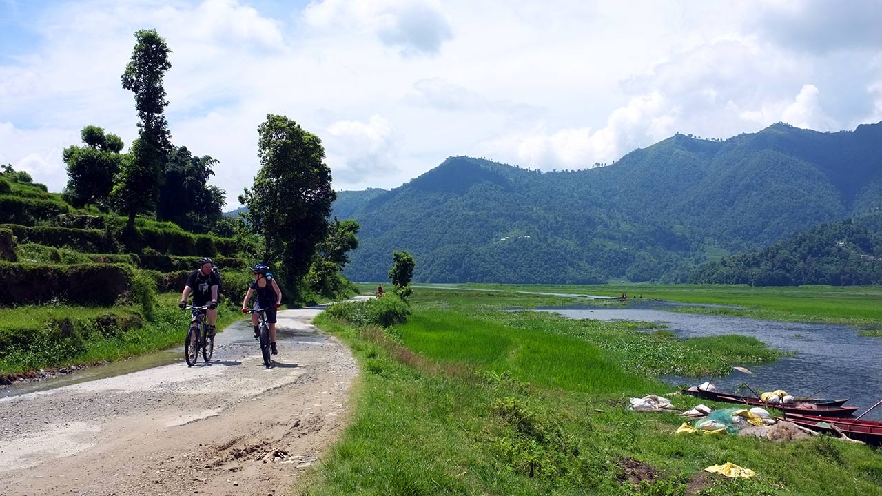 A mountain biking couple is enjoying the ride along the Shore of Fewa Lake on a sunny day in Pokhara.