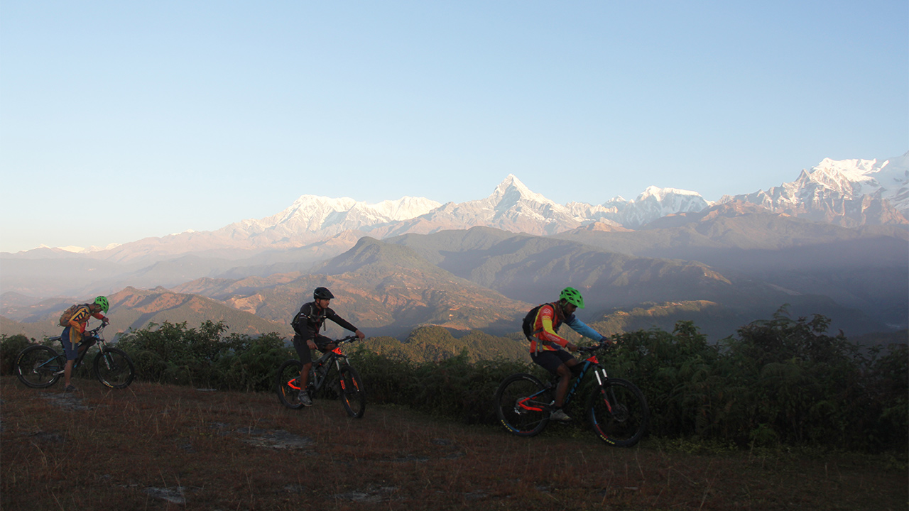 Mountain bikers are setting up for a ride with the view of Annapurna mountain range.