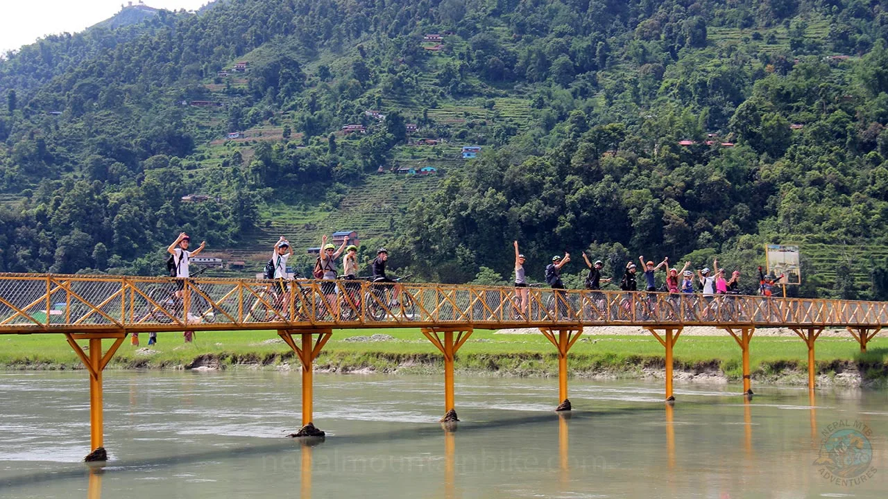 Group of mountain bikers are taking picture over the bridge during MTB day tour in Pokhara, Nepal.