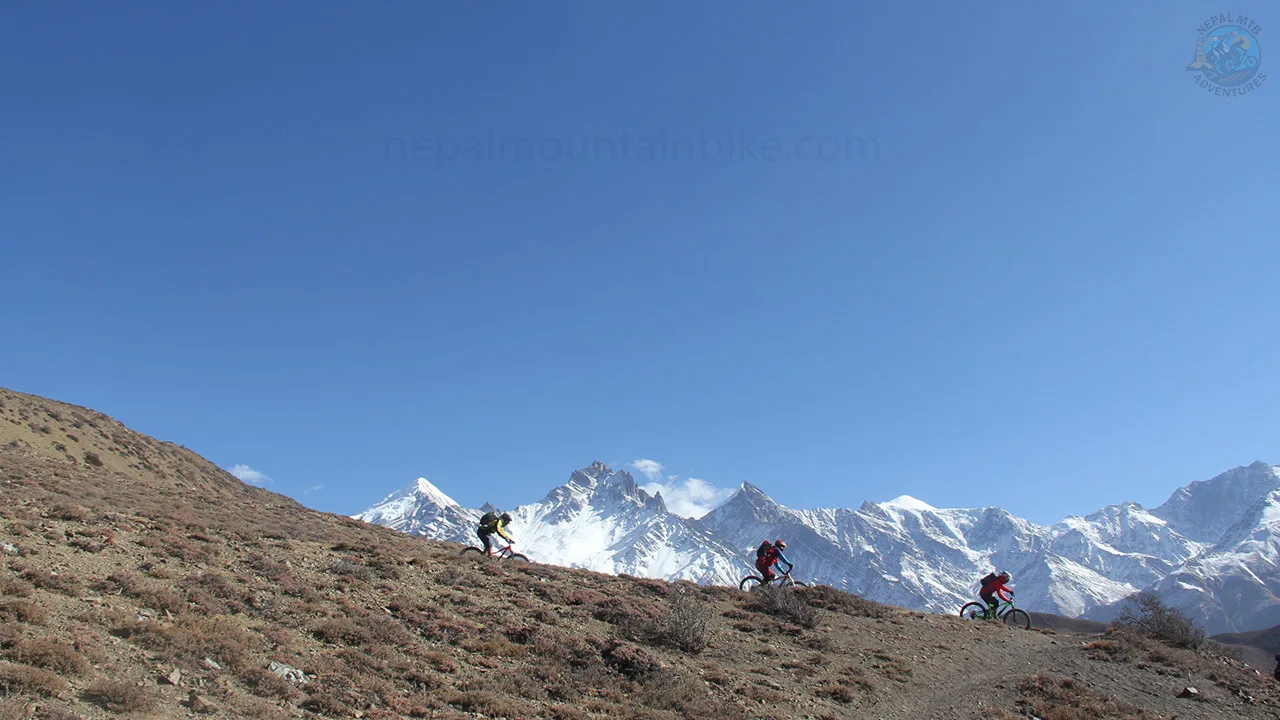 Mountain bikers rolling down the Lupra singletrack during the Himalayan guided MTB adventure in Nepal.