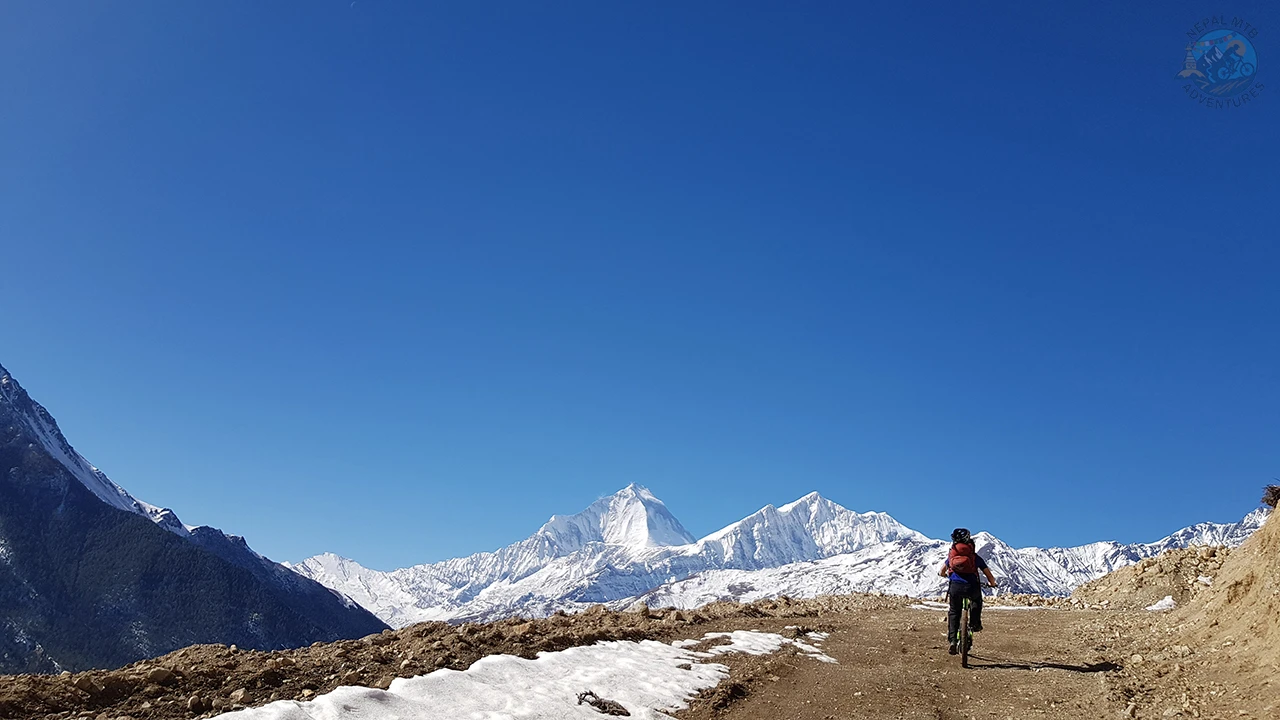 A mountain biker enjoys the scenic ride during the mountain biking tour in Nepal.