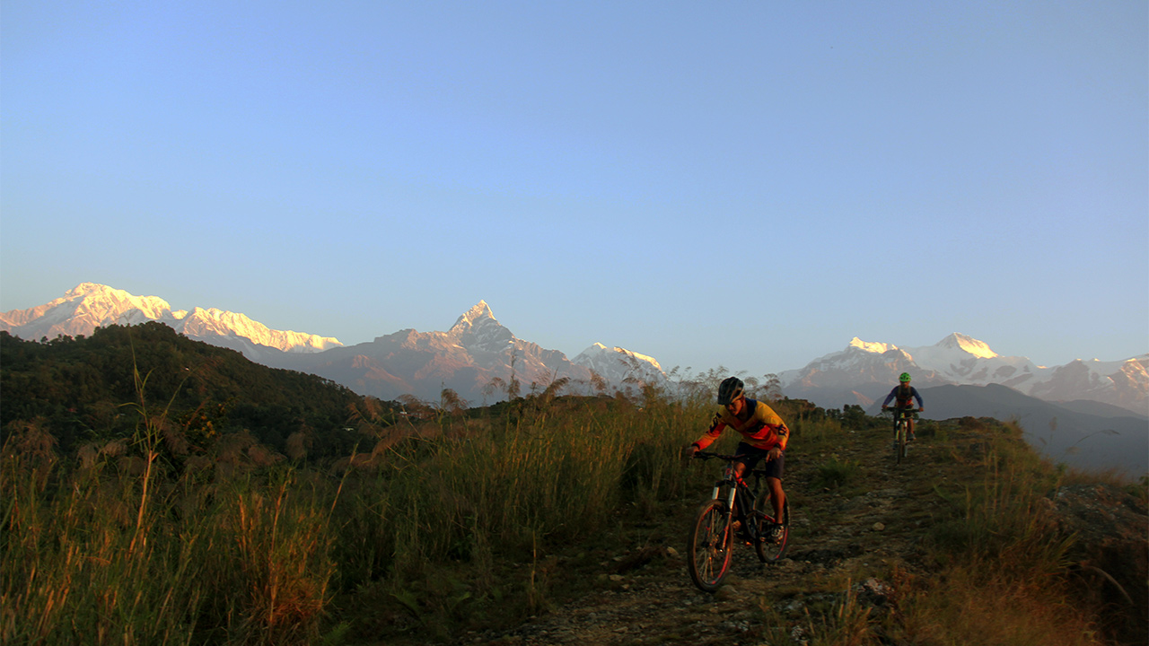 Two mountain bikers are rolling down from Sarangkot during their downhill tour in Pokhara.